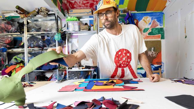 Walker arranging a selecting of cuttings from old wetsuits to create his art. Picture: Kelly Barnes