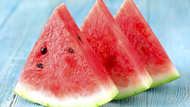 Three pieces of watermelon on wooden background