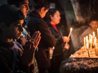 Clash of faiths ... Iraqi Christians light candles inside a shrine. Source: Getty