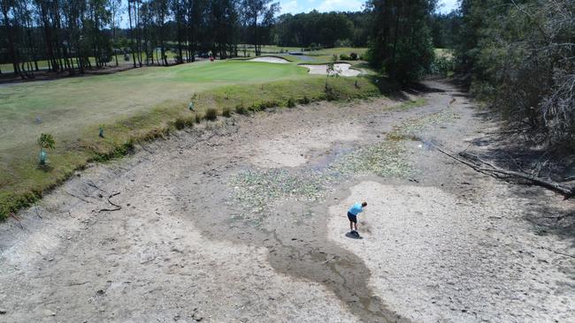 Gainsborough Greens golf course shows the contrasting fortunes of the drought. Instead of water four metres deep, golfer Ben Ring plays out of an empty dam to the lush 2nd green. Picture: Glenn Hampson