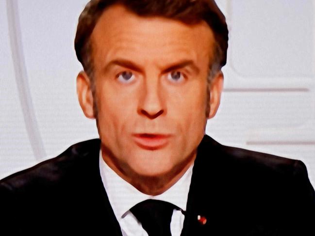 This photograph taken on March 5, 2025, shows a television screen broadcasting France's President Emmanuel Macron addressing a live interview on French TV at the Elysee Presidential Palace in Paris. Emmanuel Macron announced on March 5, 2025, that France will gather next week in Paris the chiefs of staff from countries ready to guarantee a future peace in Ukraine. (Photo by Ludovic MARIN / AFP)