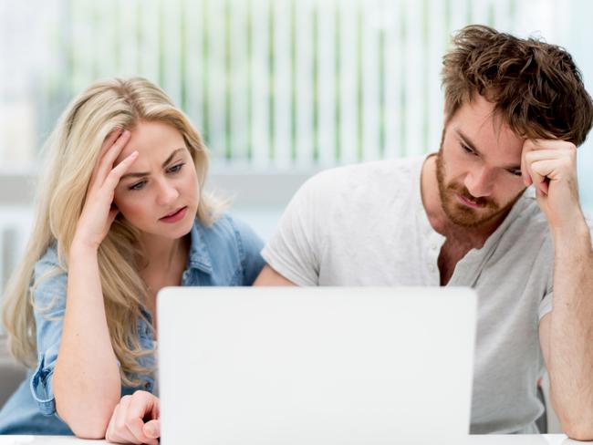 A young couple discussing their finances with each other in front of their computer at home. Picture: iStock.