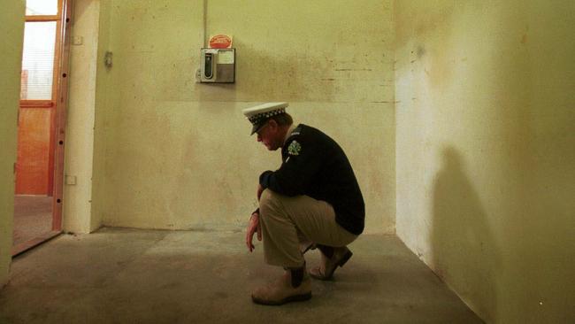 A police officer in the Snowtown bank vault where eight bodies were found inside acid-filled drums.