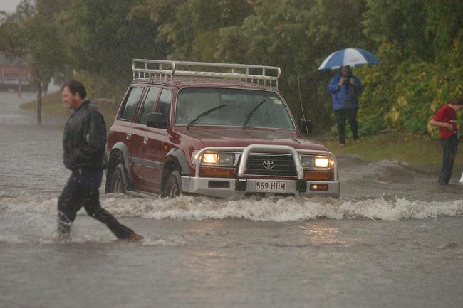 Gold Coast, June 30, 2005. A Four wheel drive vehicle crosses a flooded intersection at Varsity Lakes on Queensland’s Gold Coast today. Widespread flooding has hit the popular tourist area, known for its sunshine and sandy beaches, with reports of rainfall reaching 80mm per hour in some regions. (AAP Image/Tony Phillips)