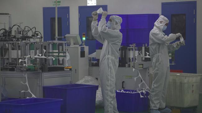 Workers inspect masks at a production line of Wuhan Zonsen Medical Products in Wuhan. Picture: AP