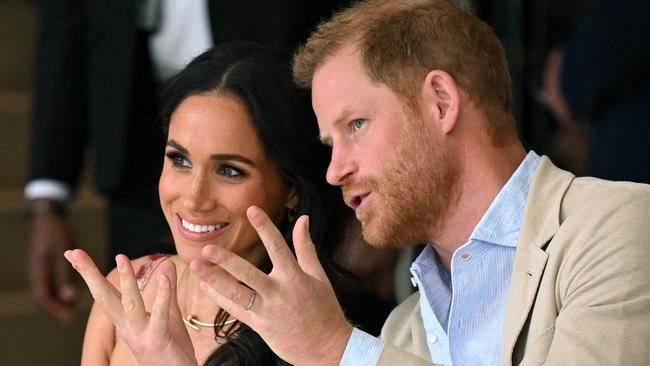 Britain's Prince Harry (R), Duke of Sussex, speaks with his wife Meghan Markle while attending a show during a visit to the National Centre for the Arts in Bogota on August 15, 2024. Prince Harry and his wife, American actress Meghan Markle, arrived in Colombia at the invitation of vice President Francia Marquez, with whom they will attend various meetings with women and young people to reject discrimination and cyberbullying. (Photo by RAUL ARBOLEDA / AFP)