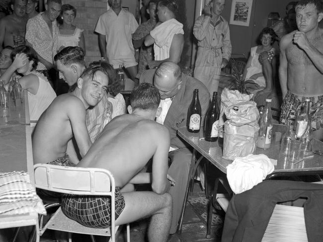 1959: A detective questions guests at a pyjama party at the Beachcomber private hotel in Surfers Paradise after 10 licensing squad police made their second raid on the premises.