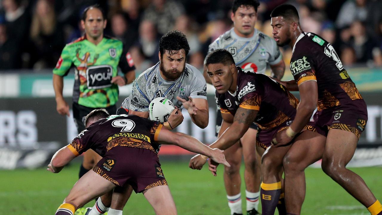 Peta Hiku of the Warriors is tackled by the Broncos pack