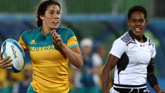 RIO DE JANEIRO, BRAZIL — AUGUST 06: Charlotte Caslick of Australia runs with the ball to score a try under pressure of Luisa Tisolo of Fiji during a Women's Pool A rugby match between Australia and Fiji on Day 1 of the Rio 2016 Olympic Games at Deodoro Stadium on August 6, 2016 in Rio de Janeiro, Brazil. (Photo by David Rogers/Getty Images)