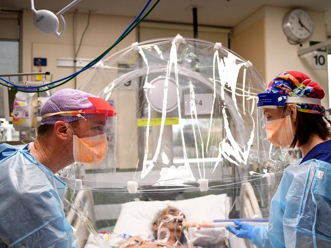 ICU nurse Michelle Spiteri and anaesthetist and intensive care physician Dr Forbes McGain attend to a Covid-19 patient under the Covid Hood developed by McGain and Melbourne University. They are in  the ICU ward of Western Health's Footscray Hospital. CLIENT: WESTERN HEALTH. PICTURE : PENNY STEPHENS. FRIDAY 17TH JULY 2020