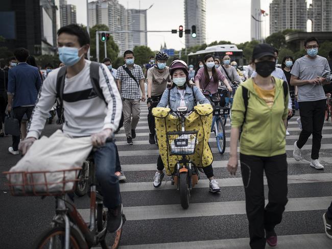 Residents wears face masks while riding their bicycles in Wuhan. Picture: Getty Images