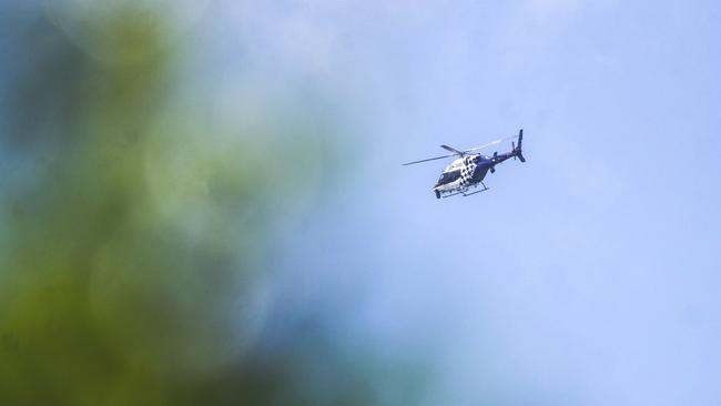 The Polair 2 helicopter flies laps over Gilston in search of three alleged armed robbers on the loose. Photo: Luke Sorensen