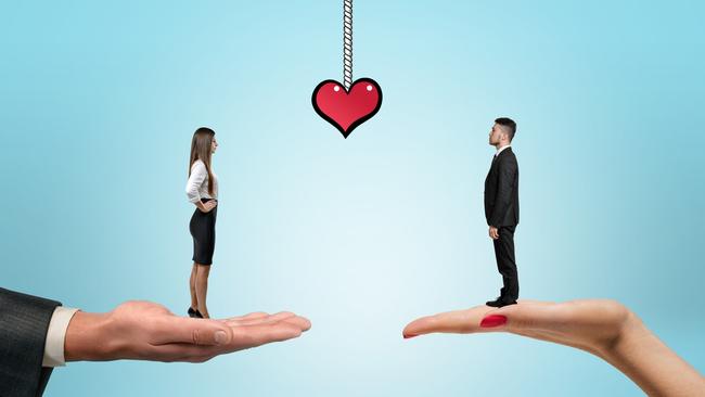 Businessman and businesswoman standing on the women's and men's hands and drawn heart between them. Office romance. St Valentine's day. Love and tenderness. Relationships at work. Istock