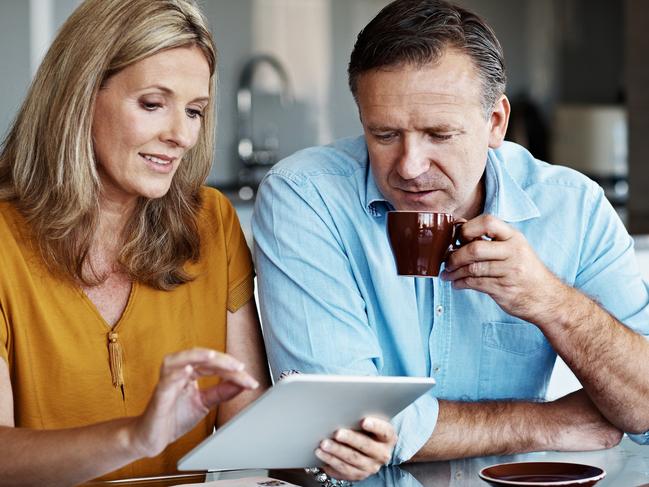 Shot of a mature couple paying their bills online from home