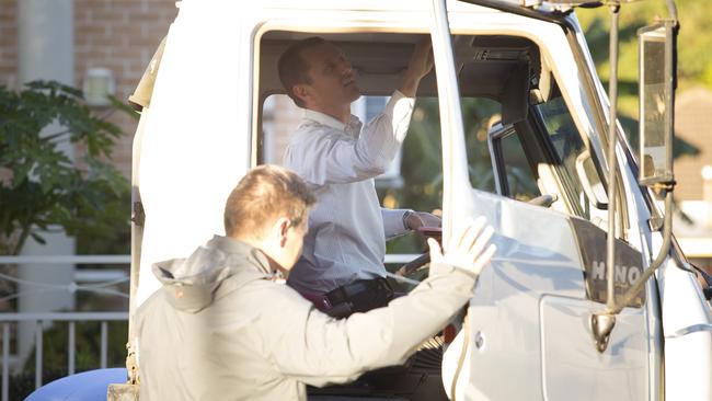 Detectives search the inside the cab of the truck the wanted male was driving.