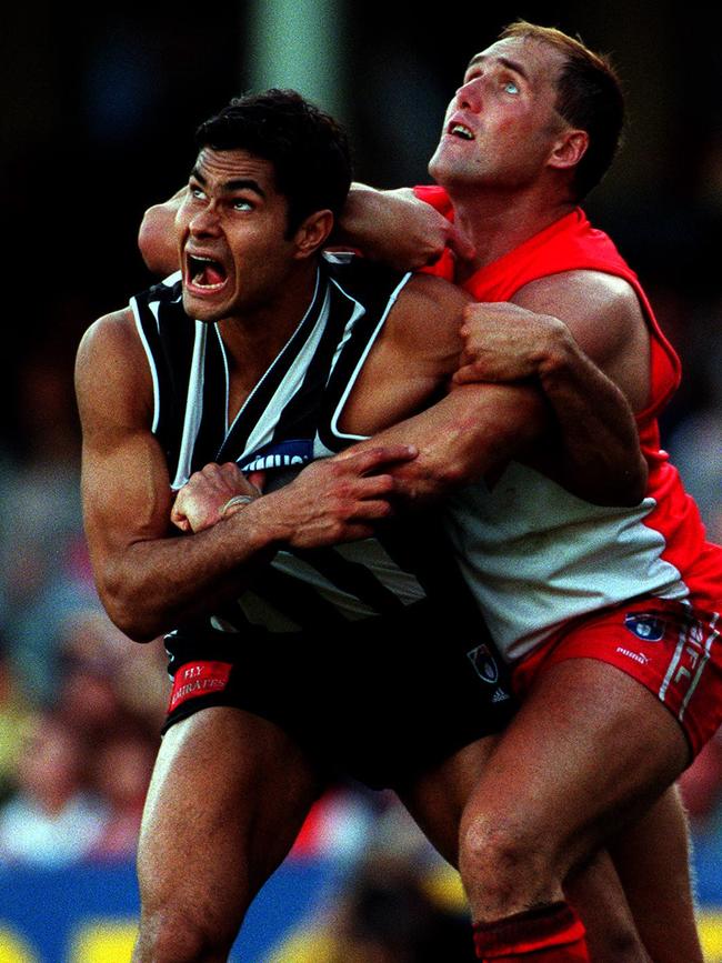 Mal Michael playing on Tony Lockett where the Swan went past Gordon Coventry’s record of 1299 goals.