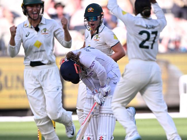 England's Tammy Beaumont (C) reacts after being bowled by Australia's Alana King (R) on the third day of the Women's Ashes cricket Test match between Australia and England at the Melbourne Cricket Ground (MCG) in Melbourne on February 1, 2025. (Photo by William WEST / AFP) / --IMAGE RESTRICTED TO EDITORIAL USE - STRICTLY NO COMMERCIAL USE--