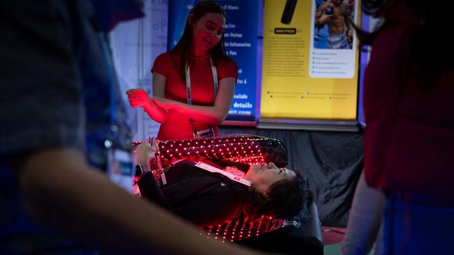 A person lies in a red light wrap at the Dr Fuji/Acigi booth during the Consumer Electronics Show. Picture: AFP