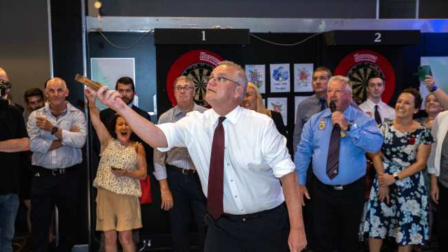 Prime Minister Scott Morrison plays a game of two-up at Cazaley's - Palmerston Club on Anzac day. Picture: Jason Edwards