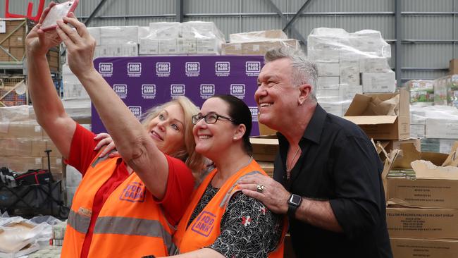 Jimmy Barnes packing food packages with volunteers at the Foodbank warehouse in Glendenning. Picture: Jonathan Ng