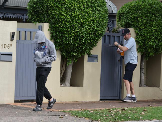 A person in a grey hoodie exits the property. Picture: Rohan Kelly