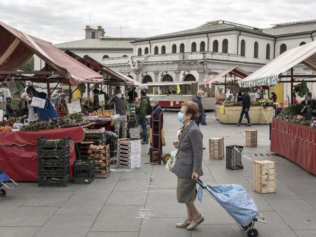 A woman wears a face mask as she pulls her shopping cart at open air Porta Palazzo market, which reopened after two months of closure, in Turin, northern Italy. Picture: AP