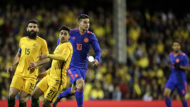 Colombia's James Rodriguez, center, duels for the ball with Australia's Mile Jedinak, left, and Massimo Luongo