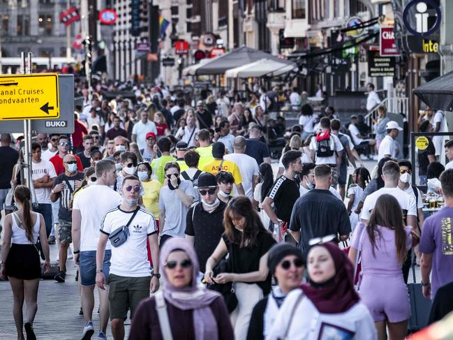 Tourists walk in the center of Amsterdam on August 21, 2020 as the Netherlands tighten up supervision of the measures to prevent further spread of the COVID-19 (novel coronavirus). (Photo by Ramon VAN FLYMEN / ANP / AFP) / Netherlands OUT