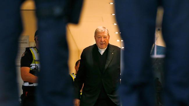 George Pell walking with a police escort from his lawyers office to the Melbourne Magistrates' Court in October 2017. Photo: Darrian Traynor