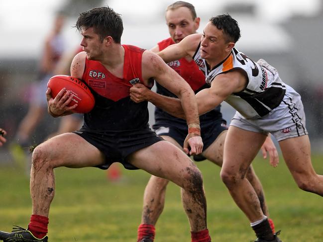 Tullamarine’s Jack Burns tries to escape the clutches of Craigieburn’s Liam Middleton earlier this season. Picture: Andy Brownbill