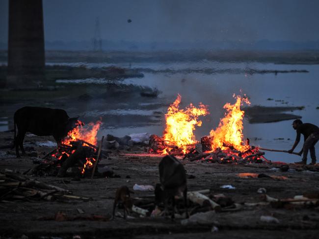 A worker cremates unclaimed bodies of people who died from COVID-19 at a mass crematorium site on the banks of the Ganges river. Picture: Ritesh Shukla/Getty Images