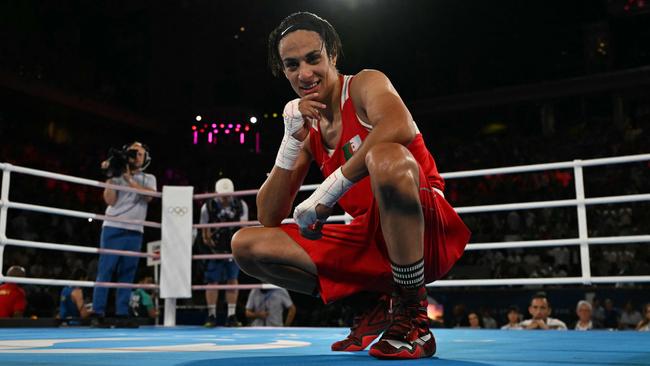 TOPSHOT - Algeria's Imane Khelif reacts after beating China's Yang Liu (Blue) in the women's 66kg final boxing match during the Paris 2024 Olympic Games at the Roland-Garros Stadium, in Paris on August 9, 2024. (Photo by MOHD RASFAN / AFP)