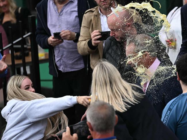 TOPSHOT - A person throws a drink in the face of newly appointed leader of Britain's right-wing populist party, Reform UK, and the party's parliamentary candidate for Clacton, Nigel Farage, during his general election campaign launch in Clacton-on-Sea, eastern England, on June 4, 2024. Nigel Farage on Monday said he would stand as a candidate for the anti-immigration Reform UK party in Britain's general election next month, after initially ruling out running. "I have changed my mind... I am going to stand," Farage, 60, told a news conference. He will seek election on July 4 in the fiercely pro-Brexit seat of Clacton, southeast England. (Photo by Ben Stansall / AFP)