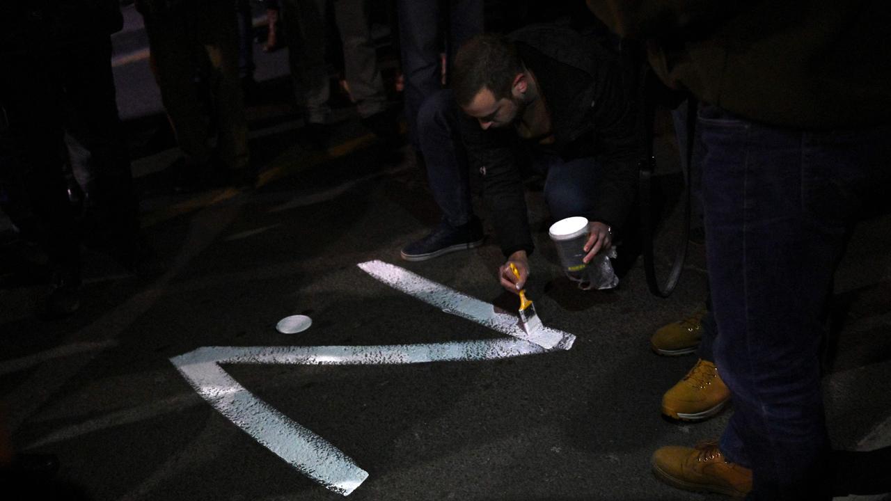 A protester paints the "Z" sign on a street, in reference to Russian tanks marked with the letter. Picture: Andrej Isakovic / AFP