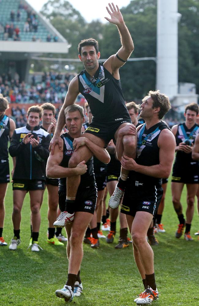 Dom Cassisi is chaired off by Kane Cornes and Jay Schulz in his final game for Port Adelaide. Picture: Simon Cross