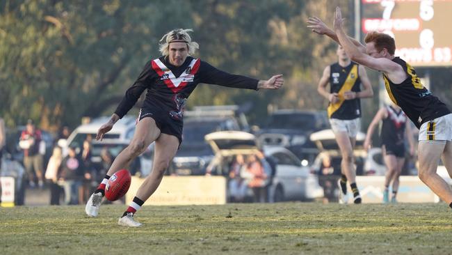 MPNFL: Devon Meadows’ Brady O’Toole gets a kick away under pressure from Luke Kranzbuhler of Seaford. Picture: Valeriu Campan