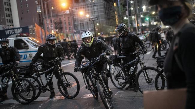 Police cycle in to arrest protesters refusing to get off the streets during an imposed curfew.