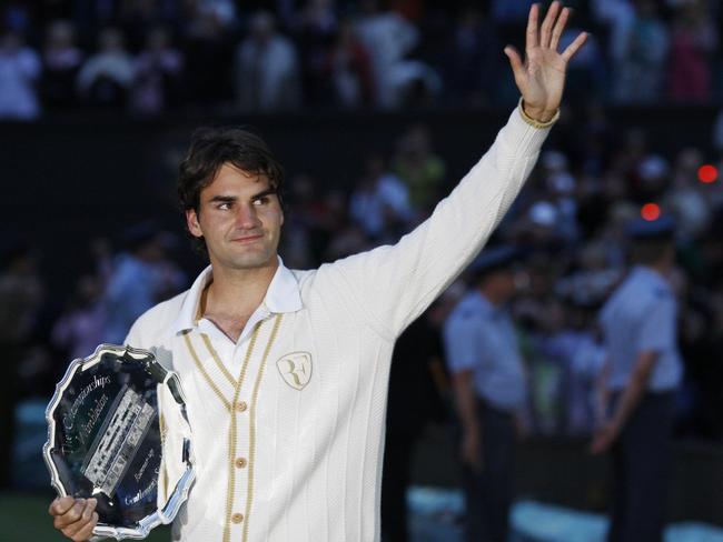 07/07/2008 WIRE: Switzerland's Roger Federer waves holding his trophy after being defeated by Spain's Rafael Nadal during their final tennis match of the 2008 Wimbledon championships against at The All England Tennis Club in southwest London, on July 6, 2008. Nadal won 6-4, 6-4, 6-7, 6-7, 9-7. AFP PHOTO / ADRIAN DENNIS