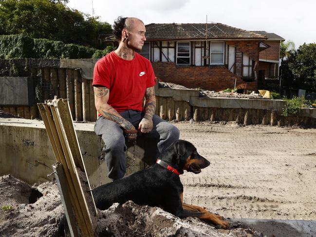 James Ward-Collins and his dog Mazwellin front of their damaged rental home. Picture: Richard Dobson