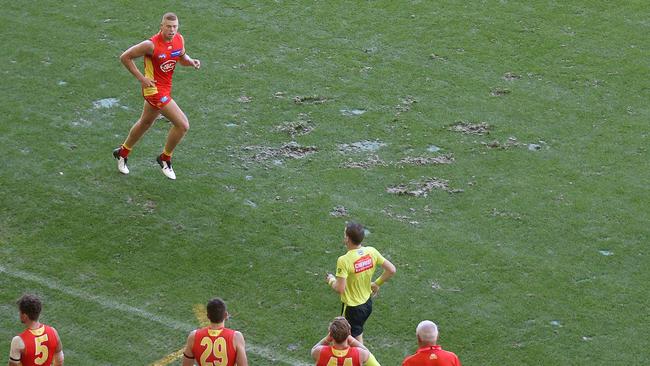 Gold Coast’s Peter Wright jogs past the interchange bench at Marvel Stadium. Picture: Michael Klein.