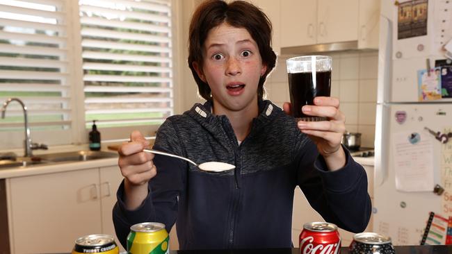 Liliana, 10, is shocked at the amount of sugar in a can of soft drink. Picture: Michael Klein