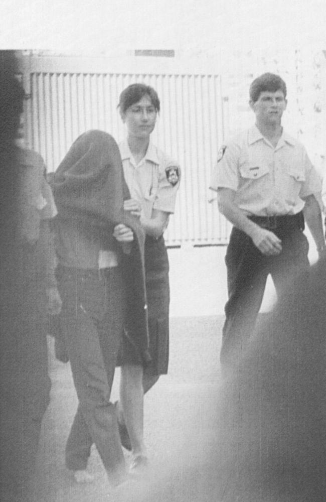 A blanket over her head, Catherine Birnie is led to a van by police officers in Perth.