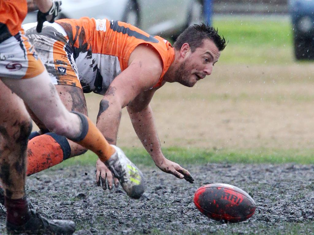 Geelong West Giants player Scott Jervies dives into the mud after the ball. Picture: Mark Wilson.