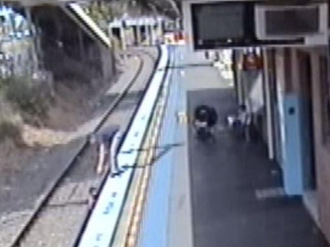 The child is barely visible on the tracks below.