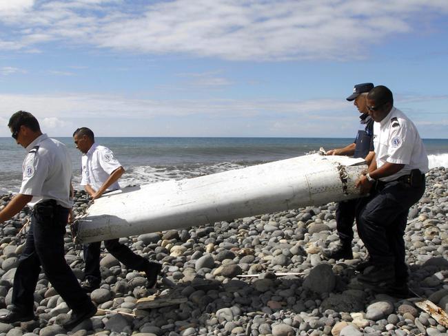 Officers carrying a flaperon washed ashore in eastern La Reunion island. Picture: EPA