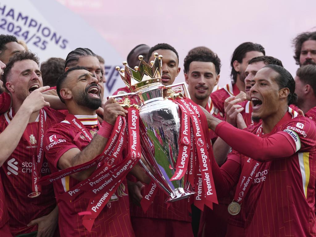 Liverpool's captain Virgil van Dijk, right, Mohamed Salah, centre left, and teammates celebrate with the winner's trophy. Picture: AP