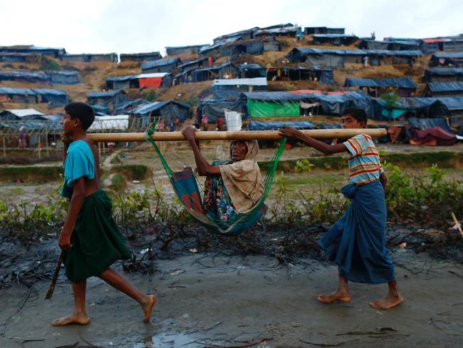 Rohingya refugee children carry an old woman in a sling near Balukhali makeshift refugee camp in Cox's Bazar, Bangladesh, September 13, 2017. Picture: Danish Siddiqui/Reuters