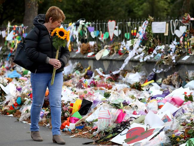 A woman walks past flowers and tributes in memory of the 50 lives that were lost in the March 15th mosque shootings in Christchurch. Picture: AFP