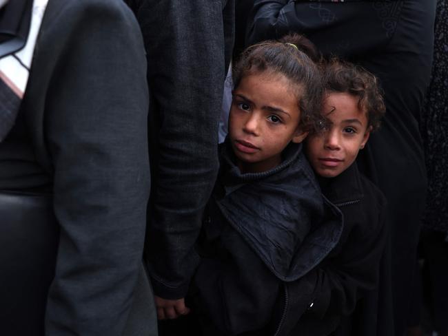 Palestinians wait in a queue to receive bread outside a bakery in Khan Yunis. The average age of the war dead in Gaza is aged below 9. Picture: AFP