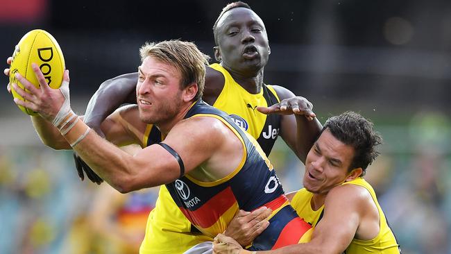 Adelaide’s Daniel Talia tackled by Richmond’s Daniel Rioli and Mabior Chol. Picture: Mark Brake/Getty